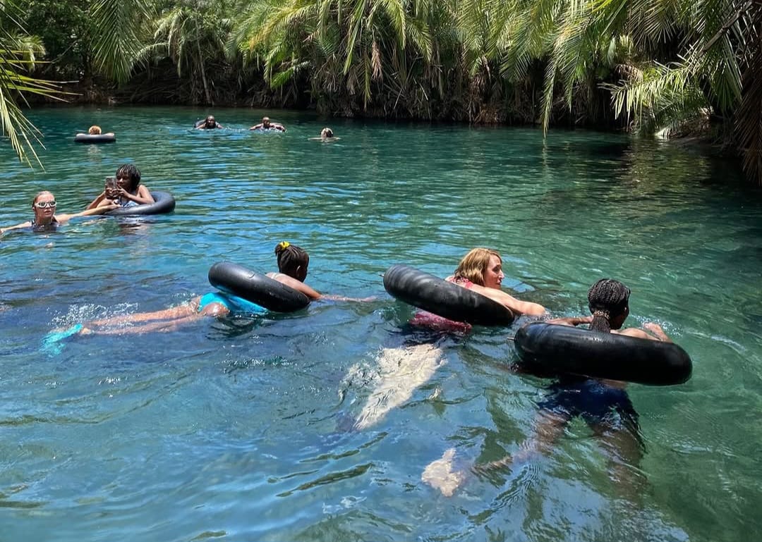 Tourists swimming in crystal-clear waters at Chemka Hot Springs during Tanzania nature day trip and Kikuletwa Springs tour from Arusha and Moshi