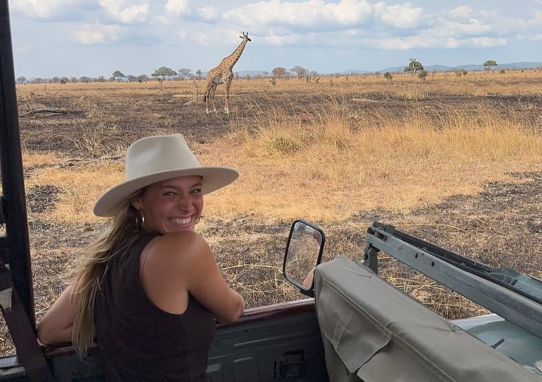 Client in safari car observing giraffe nearby during Tanzania Wildlife Safari and Big Five game drive experience in Tarangire National Park
