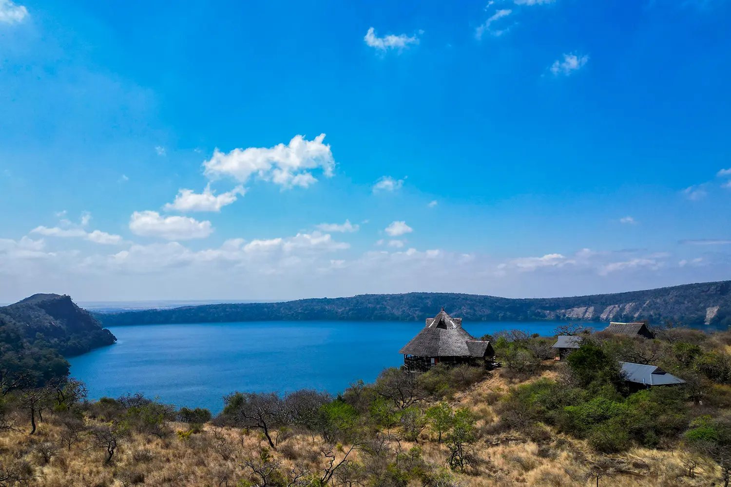 Scenic view of Lake Challa with calm waters and surrounding lush greenery near Mount Kilimanjaro.