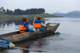 Visitors paddling a traditional canoe on the lake