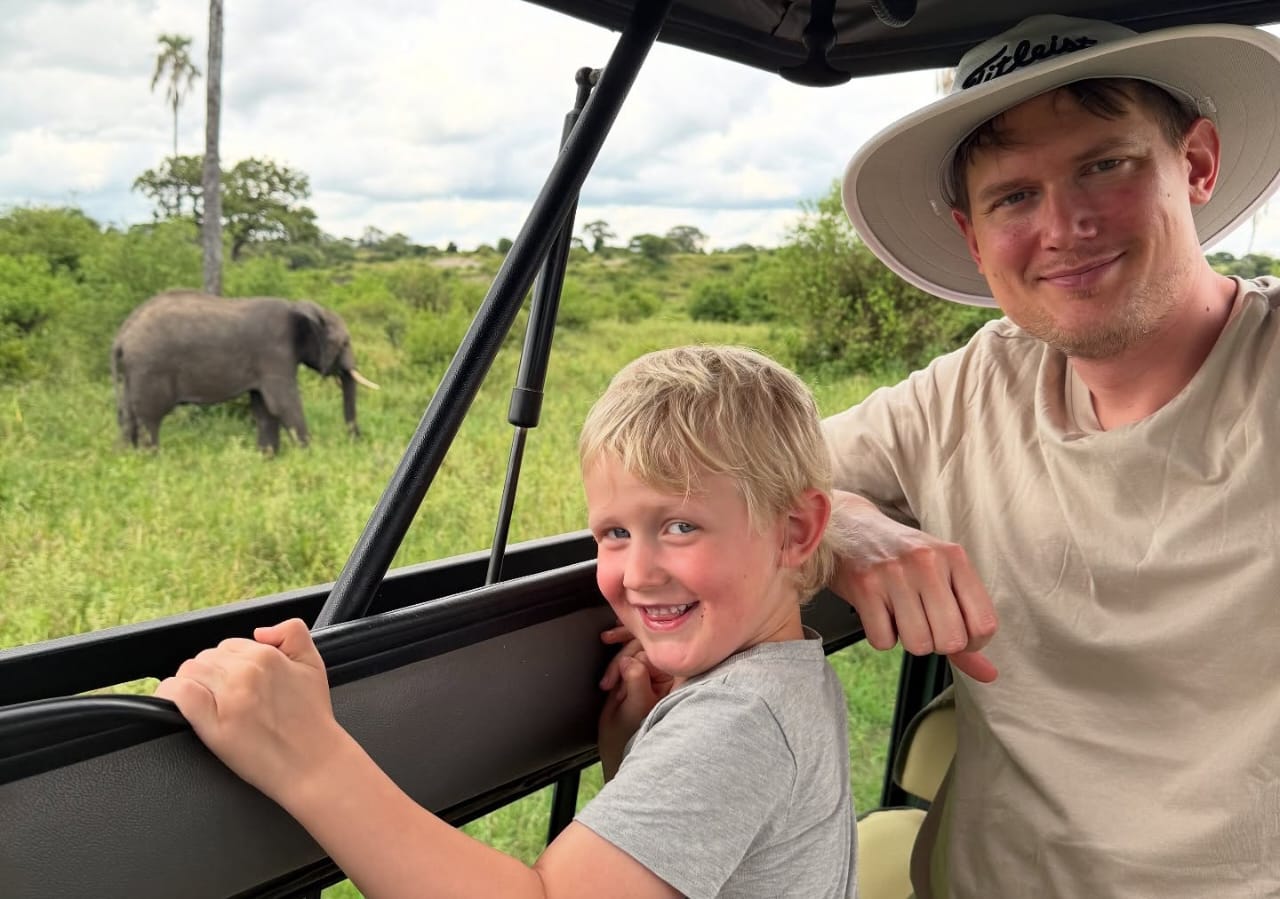 Family enjoying an elephant sighting from a safari vehicle during a Tanzania Wildlife Safari in Serengeti National Park on a Big Five safari adventure
