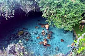 Exploring the scenic Kuza Cave on Zanzibar, surrounded by lush greenery and crystal-clear waters