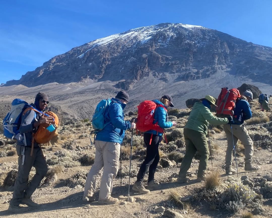 Climbers ascending Mount Kilimanjaro on a steep trail, trekking through alpine terrain during their Umbwe Route expedition in Tanzania.
