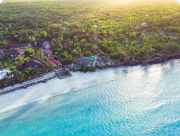 Zanzibar beach with crystal-clear waters, soft sand, and sunny skies.