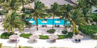 Beachfront resort in Zanzibar with palm trees, white sand, and clear turquoise waters perfect for seaside relaxation.