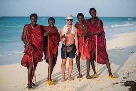 Zanzibar local village with traditional huts, people in colorful attire, showcasing Swahili culture and lifestyle.