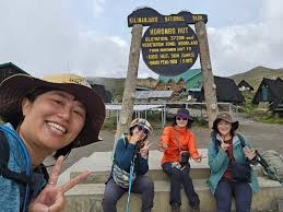 Mount Kilimanjaro peak with climbers ascending under clear blue sky