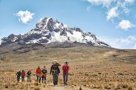Hikers climbing Mount Kilimanjaro along scenic trail with panoramic views in Tanzania